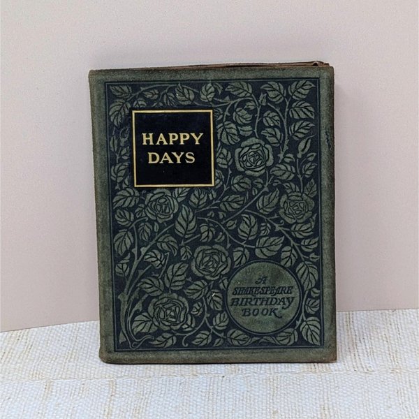A small, 1904 leather-bound book titled "Happy Days: A Shakespeare Birthday Book." The dark cover is intricately embossed with a floral rose pattern and gold-foil lettering, showing a soft, aged patina on the edges.