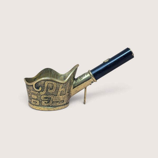 Vintage Chinese brass silk iron with black wood handle and geometric engraving.