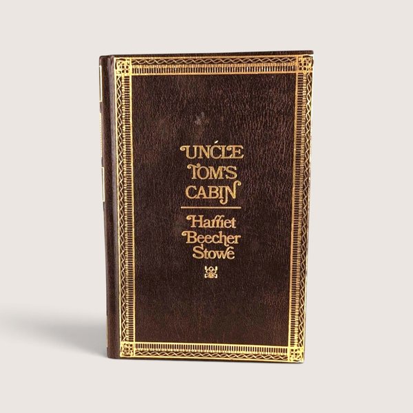 Vintage 1976 hardcover edition of Uncle Tom's Cabin by Harriet Beecher Stowe with faux-leather and gold stamped cover.