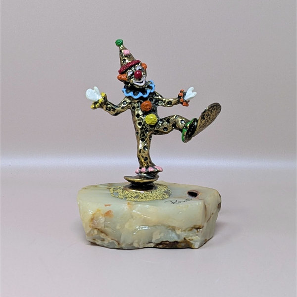 A hand-painted metal clown figurine by Ron Lee with 24k gold plating on a thick, natural onyx marble base against a neutral background.
