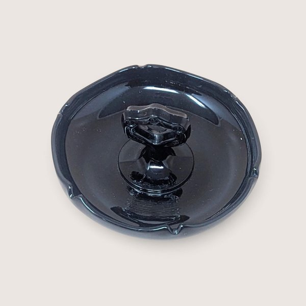 Vintage 1930s depression-era black glass trinket dish with a center handle and smooth glossy finish.