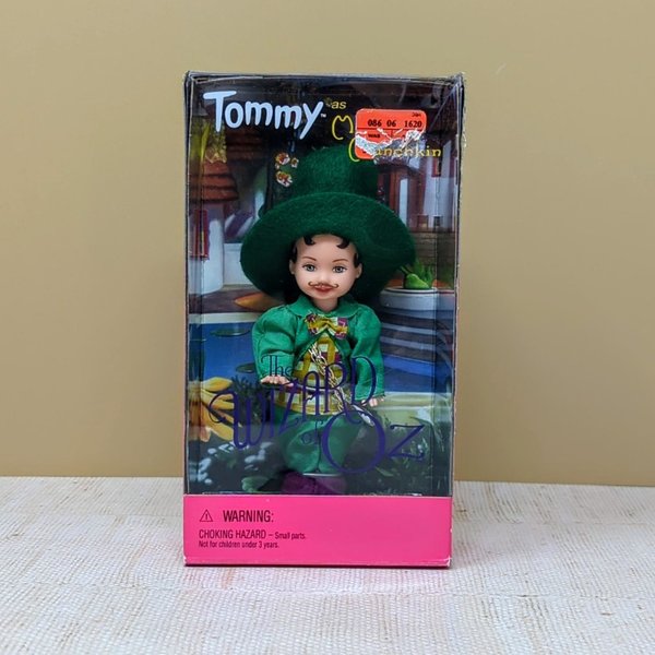 A 4.5-inch Tommy doll dressed as the Mayor Munchkin in a green jacket and hat, displayed inside its original 1999 Wizard of Oz themed window box.