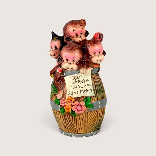 Vintage ceramic piggy bank shaped like a barrel of monkeys with painted details.