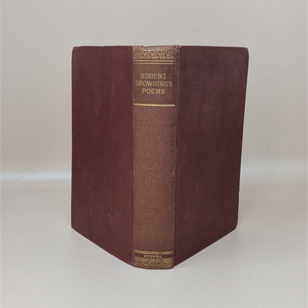 A burgundy cloth-bound hardcover book standing upright, featuring gilded typography on the spine for Robert Browning's Poems against a neutral background.