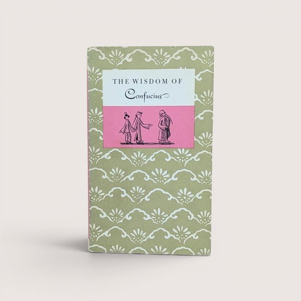 Vintage book titled The Wisdom of Confucius with a green and white patterned cover and a pink and white central label.