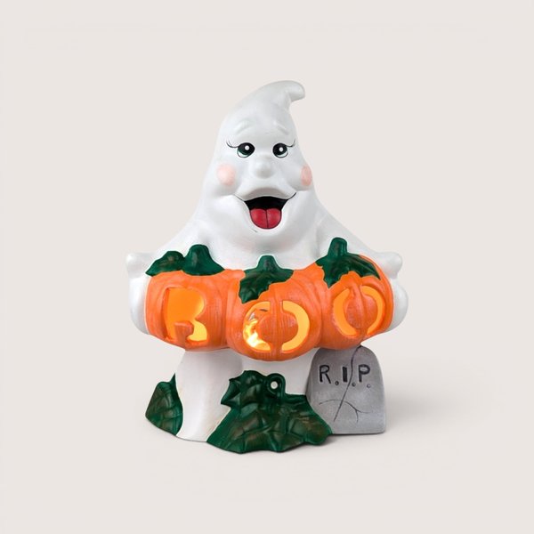A lit ceramic ghost figurine holding orange pumpkins that spell "BOO," centered on a beige background.A lit ceramic ghost figurine holding orange pumpkins that spell "BOO," centered on a beige background.