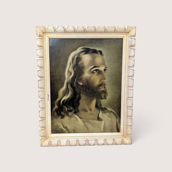 A framed vintage portrait print of Jesus Christ in profile looking upward, centered on a beige background.