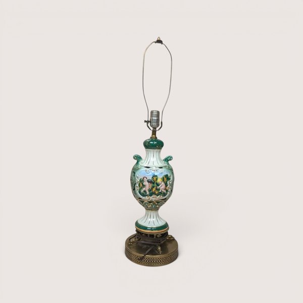 A vintage Italian ceramic table lamp featuring a green and white ornate urn body painted with cherubs.