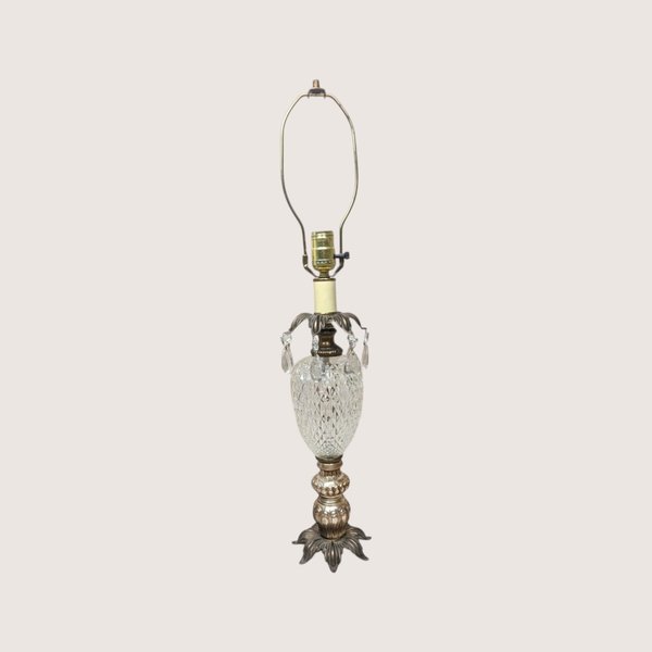 A vintage Hollywood Regency table lamp with a cut glass urn body and hanging crystal glass prisms.