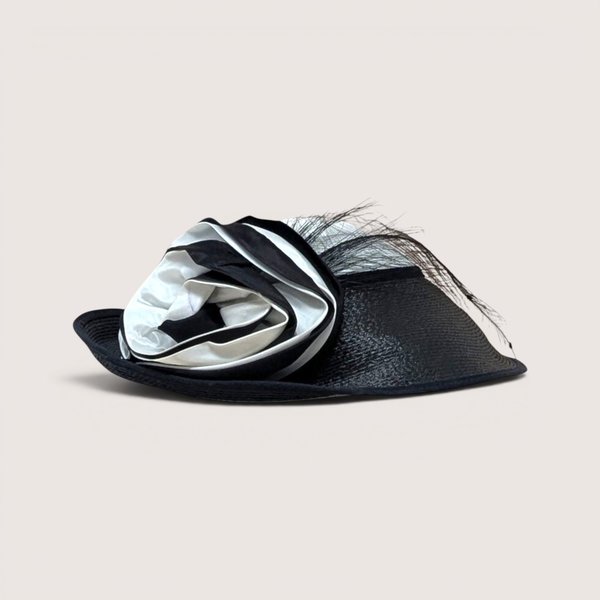 A vintage Jody G for Sylvia black and white straw hat featuring a large matching fabric rosette on the side.