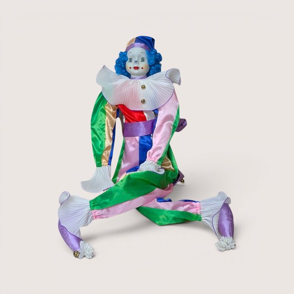 A vintage Bette Ball Victoria Ashlea Originals porcelain clown doll named Jody with blue hair and a colorful satin outfit.