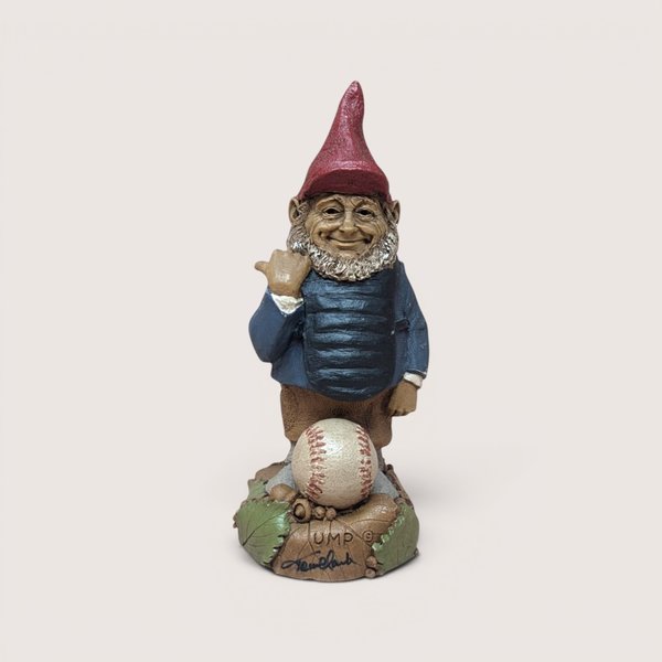 Vintage Tom Clark signed Ump baseball umpire gnome figurine standing behind a baseball on a linen background