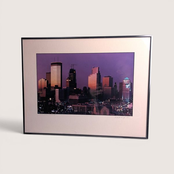 Framed and signed 1987 Rick Gravrok photograph of the illuminated Minneapolis skyline at dusk.