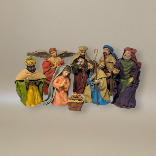 Eight-piece Nativity set made of textured fabric-mache. Includes Mary, Joseph, Baby Jesus in a manger, an angel, a shepherd, and three Wise Men. Figures feature draped, stiffened fabric robes in rich jewel tones like burgundy, gold, and teal.