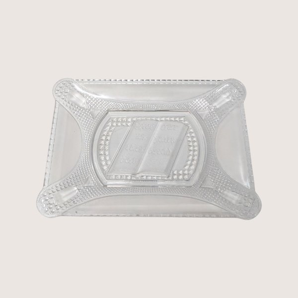 Clear rectangular pressed glass bread plate featuring an open Bible design in the center on a solid background.