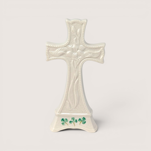 Belleek Parian china Celtic cross figurine featuring raised textures and green painted shamrocks on the base.