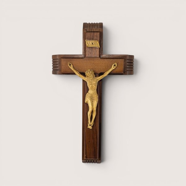 A vintage wooden wall crucifix shadow box with a corpus figure on a plain light background