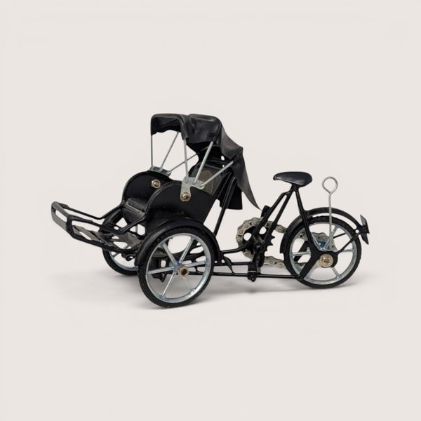 A miniature black metal model of a traditional Vietnamese cyclo rickshaw with silver wheels on a plain background