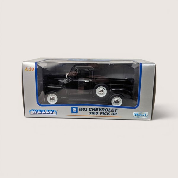 A black 1953 Chevrolet 3100 toy pickup truck sealed inside its original gray and blue Welly window display box