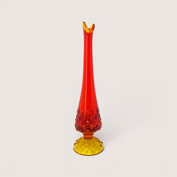 A vintage swung glass vase with a hobnail texture transitioning from a yellow base to a vibrant red pulled neck.