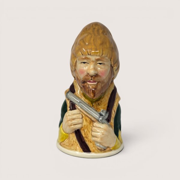 Vintage 1983 Royal Cornwall Robinson Crusoe ceramic character bell in brown and green glaze.