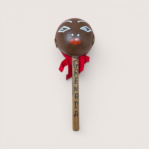 Vintage handpainted wooden Grenada souvenir maraca with a red fabric head wrap.