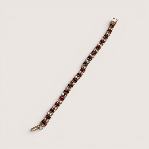 Vintage gold tone tennis bracelet set with rows of red and clear rhinestones and a fold-over clasp.