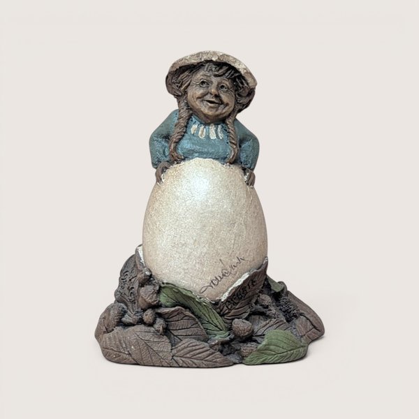Vintage signed Tom Clark "Debbie" gnome figurine peeking over a large egg with natural leaf base.