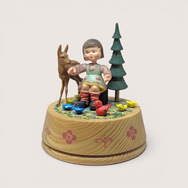 Vintage Anri wood-carved rotating music box featuring a girl, deer, and bird with hand-painted alpine details.