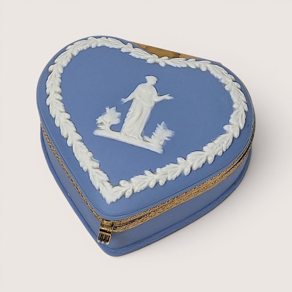 Vintage blue heart-shaped Wedgwood Jasperware trinket box with white neoclassical relief and gold-toned metal trim.