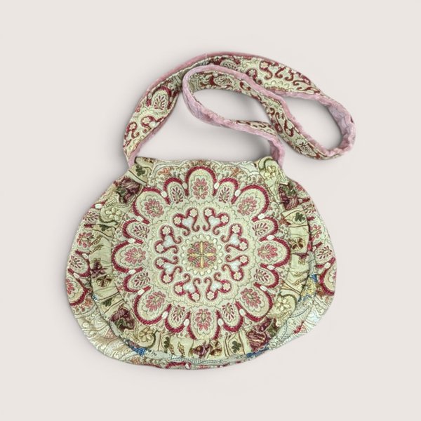 Vintage Carpet Bags of America tapestry shoulder purse with a circular mandala design in pink, cream, and red.