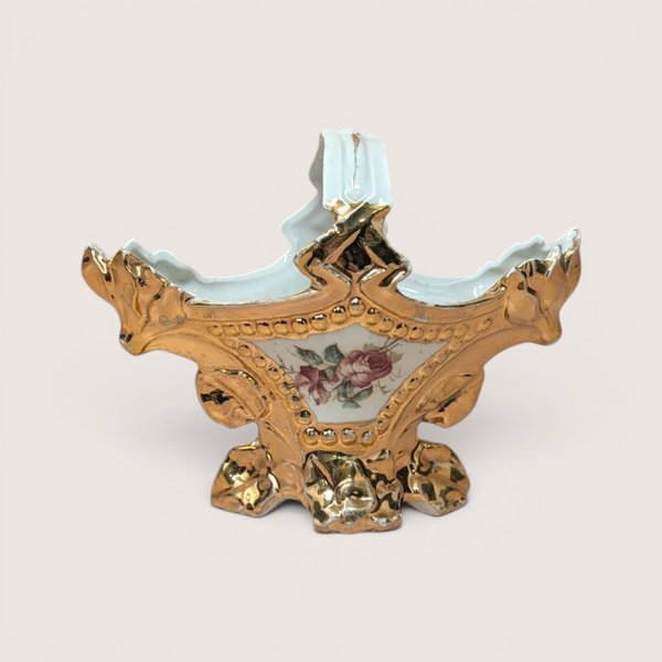 Vintage porcelain decorative basket with a floral rose painting surrounded by heavy gold gilt scrollwork and handle.
