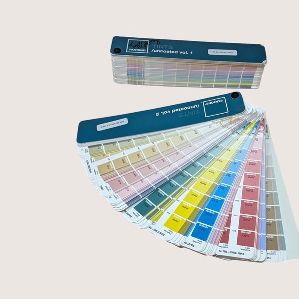 Vintage Pantone Tints Uncoated Volumes 1 and 2 color swatch fan decks fanned open showing rainbow color chips.
