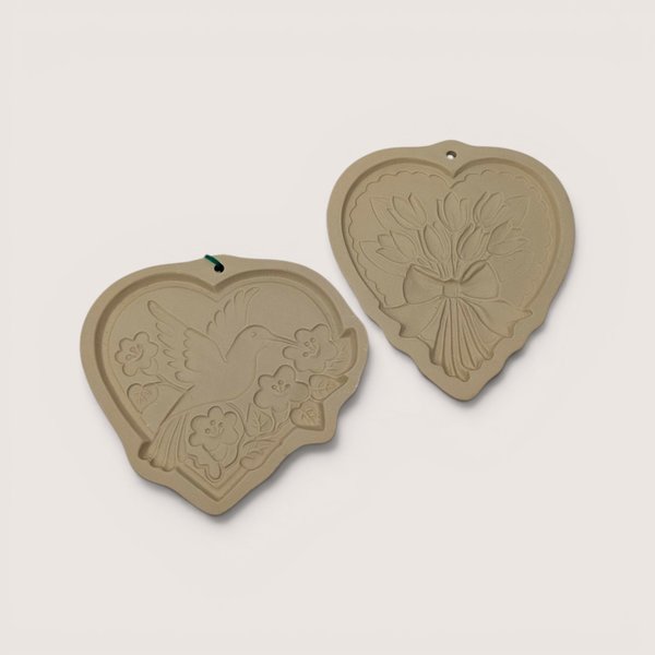 Pair of vintage 1989 and 1992 Hill Design Brown Bag stoneware heart cookie molds featuring hummingbird and tulip designs.