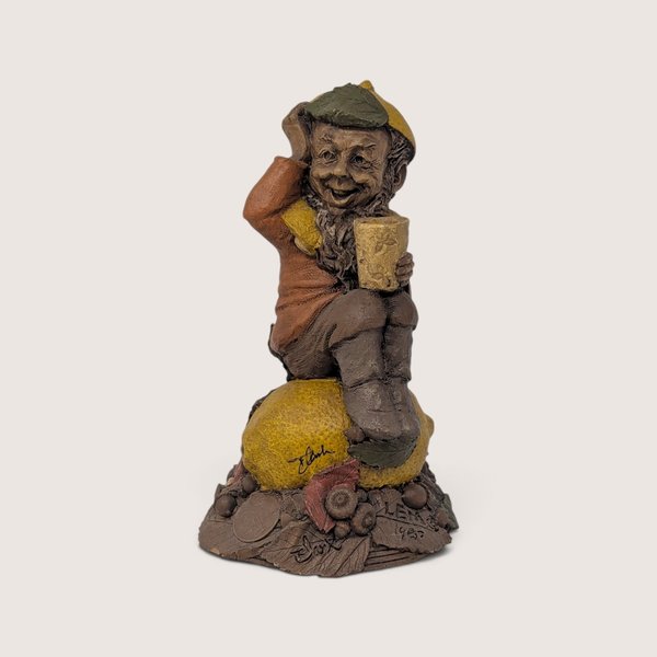 A vintage Tom Clark signed "Lem" resin gnome figurine from Cairn Studio, sitting on top of a textured lemon.