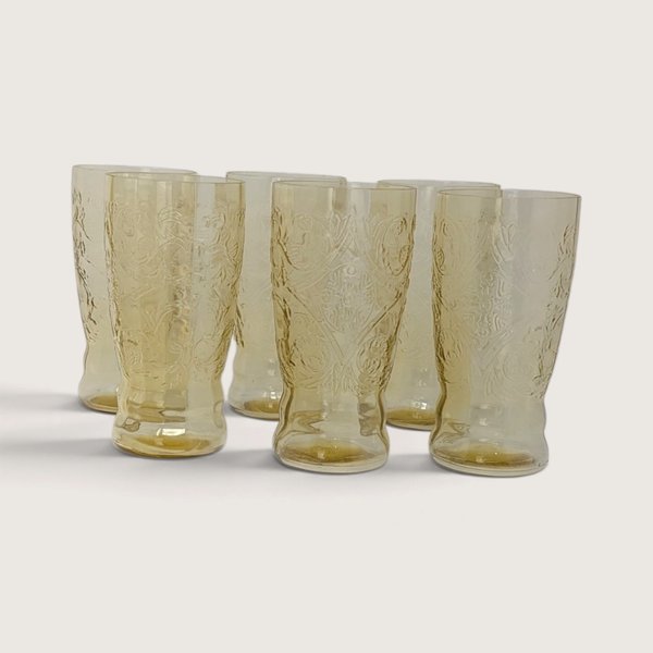 A set of six vintage amber depression glass tumblers featuring the Federal Glass Madrid scroll pattern on a neutral background.