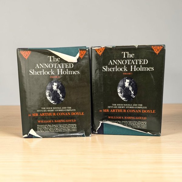 Two large hardcover books with dark green cloth bindings and metallic gold lettering on the spines. The edges of the covers shows wear.