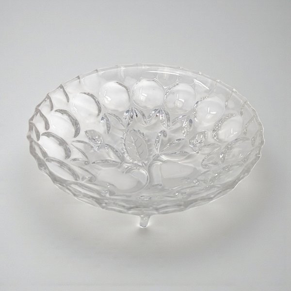 A clear pressed glass bowl with a subtle pedestal base. The interior features an intaglio fruit motif, while the rim is finished with a classic ruffled or "sawtooth" edge.