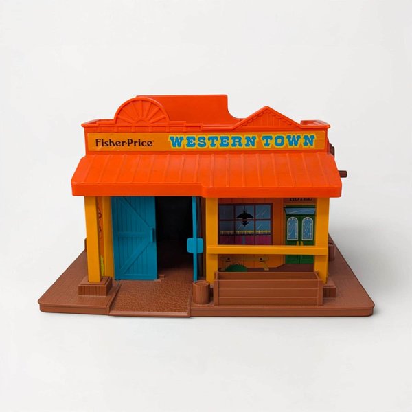A vintage plastic toy building featuring a two-story Western town design. The structure includes a brown molded "wood" exterior with a yellow balcony, blue accents, and a red jail cell door.
