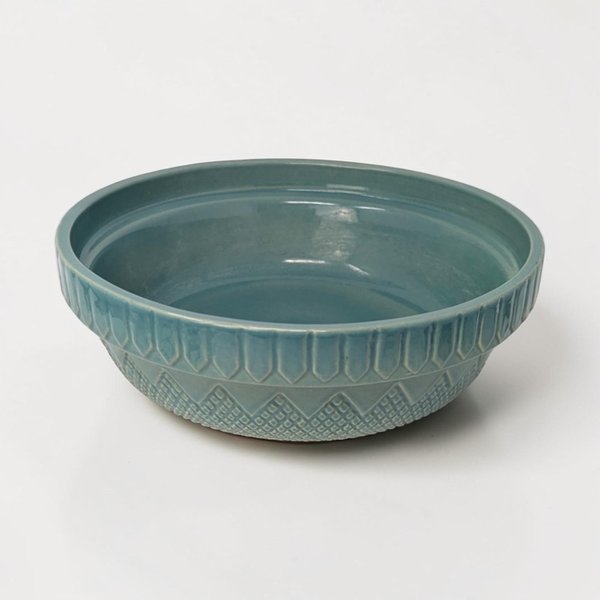 A teal stoneware bowl with an embossed geometric fence and diamond pattern on the exterior. The interior is a smooth, glossy matching teal. The silhouette is a wide, shallow basin with a slightly flared rim.